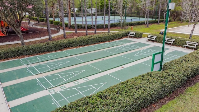 view of property's community with fence and shuffleboard