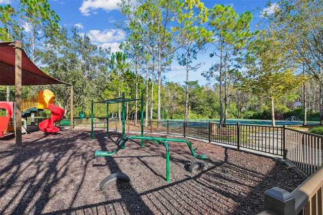 communal playground with fence and view of scattered trees