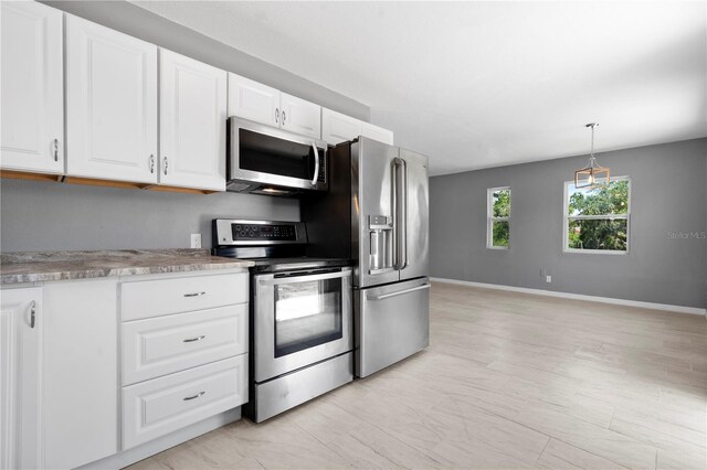 11009 Spivey Rd Unit 1, Gibsonton, FL 33534 - kitchen with stainless steel appliances, baseboards, and white cabinetry
