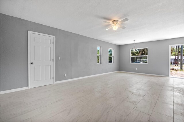 11009 Spivey Rd Unit 1, Gibsonton, FL 33534 - empty room with a ceiling fan, a textured ceiling, and baseboards