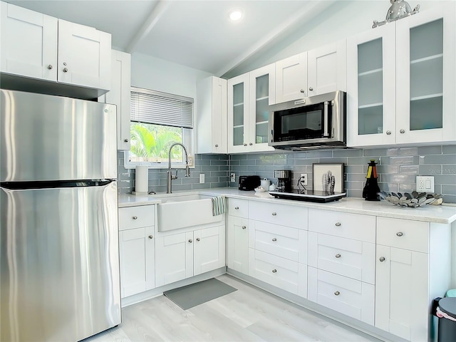 5111 28th Ave N, Saint Petersburg, FL 33710 - kitchen featuring stainless steel appliances, a sink, vaulted ceiling, tasteful backsplash, and light countertops