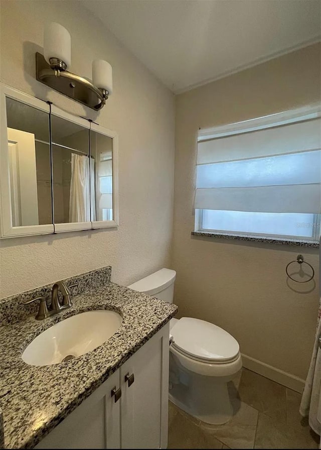 5111 28th Ave N, Saint Petersburg, FL 33710 - bathroom featuring toilet, vanity, a shower with shower curtain, and tile patterned floors