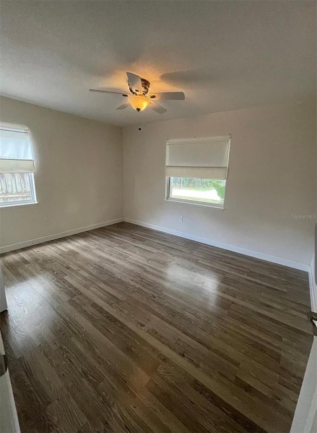 5111 28th Ave N, Saint Petersburg, FL 33710 - empty room with dark wood-type flooring, ceiling fan, and baseboards