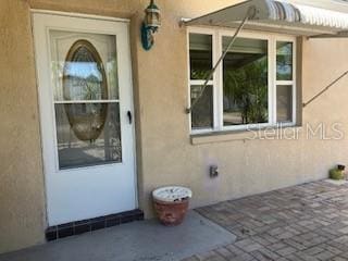 entrance to property with stucco siding