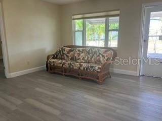 living room with baseboards, healthy amount of natural light, and wood finished floors