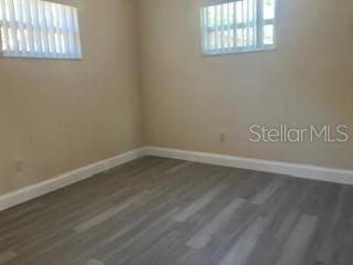 unfurnished room with wood finished floors and baseboards