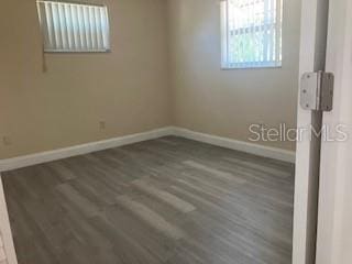 unfurnished room featuring baseboards and wood finished floors