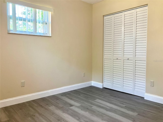 7425 W Maryland Ave W, Hudson, FL 34667 - unfurnished bedroom featuring dark wood finished floors, a closet, and baseboards