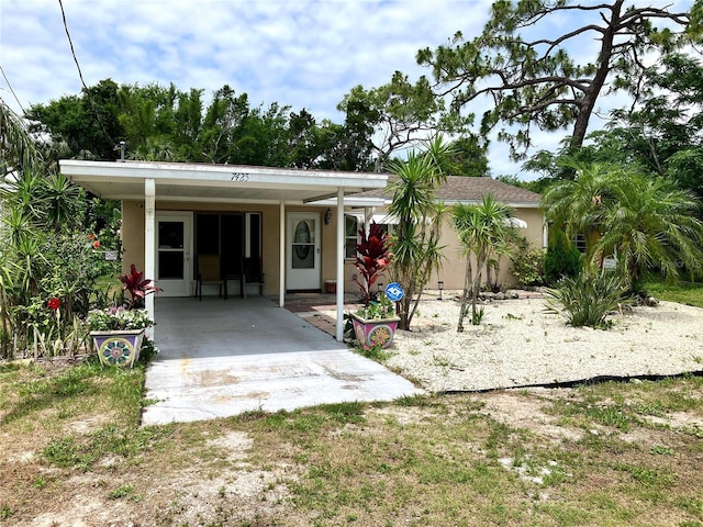 7425 W Maryland Ave W, Hudson, FL 34667 - view of front of home with stucco siding and a carport