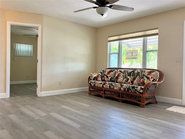 7425 W Maryland Ave W, Hudson, FL 34667 - living area featuring a ceiling fan, wood finished floors, baseboards, and a textured ceiling