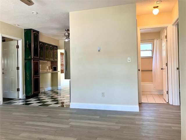 7425 W Maryland Ave W, Hudson, FL 34667 - corridor featuring baseboards, a textured ceiling, and light wood-style floors