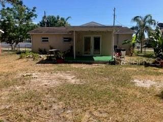 7425 W Maryland Ave W, Hudson, FL 34667 - rear view of property featuring a yard