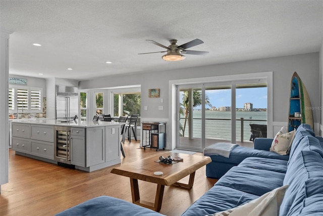 297 1st St W, Tierra Verde, FL 33715 - living area with wine cooler, a ceiling fan, light wood-style floors, a textured ceiling, and recessed lighting