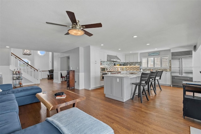 297 1st St W, Tierra Verde, FL 33715 - living area featuring stairs, a ceiling fan, light wood-style floors, and recessed lighting