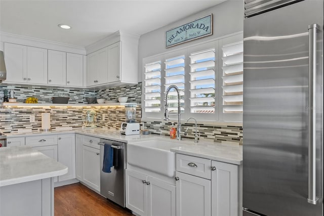 297 1st St W, Tierra Verde, FL 33715 - kitchen with stainless steel appliances, white cabinetry, backsplash, wood finished floors, and recessed lighting