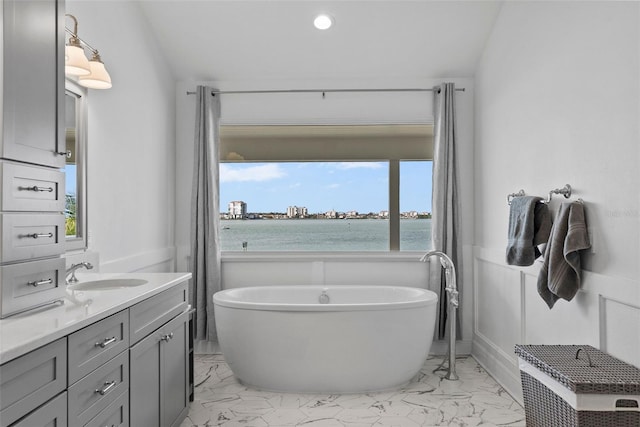 297 1st St W, Tierra Verde, FL 33715 - bathroom with marble look tile flooring, vanity, a freestanding tub, and a water view