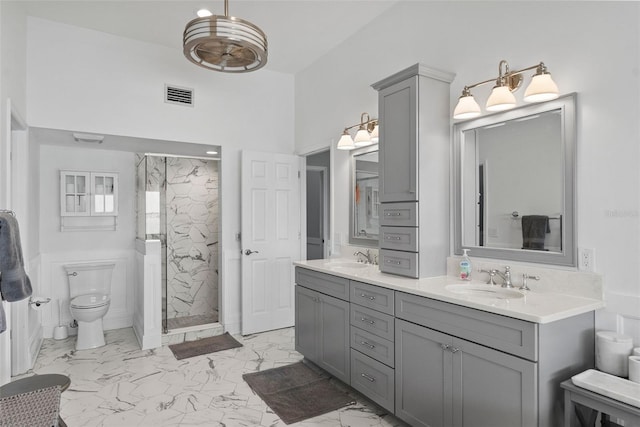 297 1st St W, Tierra Verde, FL 33715 - full bath with marble look tile flooring, a marble finish shower, double vanity, and a high ceiling