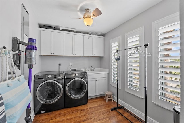 297 1st St W, Tierra Verde, FL 33715 - laundry area with cabinet space, washing machine and dryer, light wood-type flooring, and a ceiling fan
