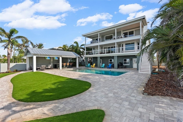 297 1st St W, Tierra Verde, FL 33715 - back of property with a balcony, stairway, a patio, and an outdoor living space