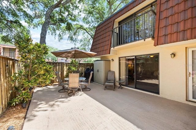 2626 2nd Ct, Palm Harbor, FL 34684 - view of patio / terrace featuring outdoor dining area, fence, a balcony, and a shed