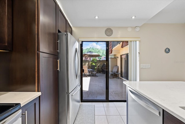 2626 2nd Ct, Palm Harbor, FL 34684 - kitchen featuring stainless steel appliances, light tile patterned flooring, dark brown cabinetry, light stone countertops, and recessed lighting
