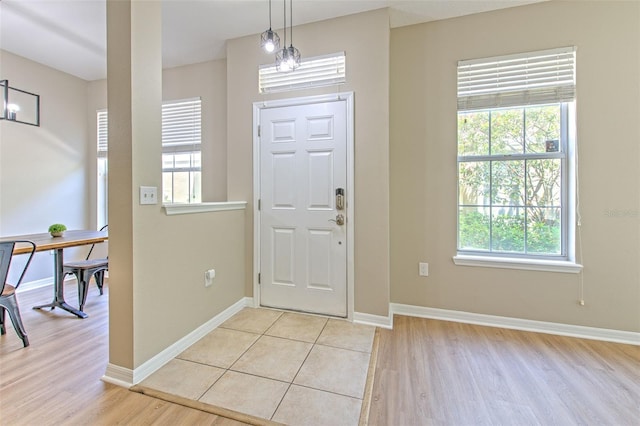 entrance foyer featuring light wood-style floors, baseboards, and plenty of natural light