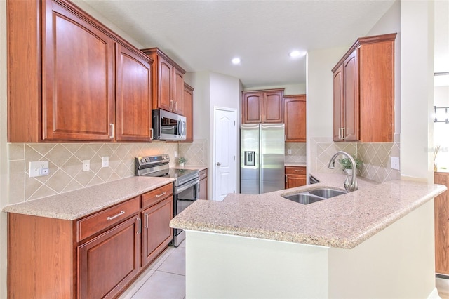 kitchen with appliances with stainless steel finishes, a sink, a peninsula, backsplash, and recessed lighting