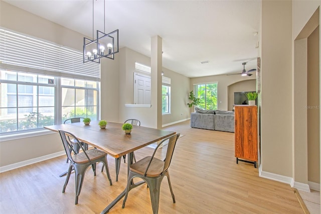 dining space featuring baseboards, light wood finished floors, ceiling fan, and a chandelier