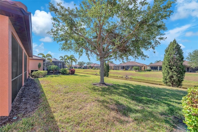 view of green lawn with a residential view