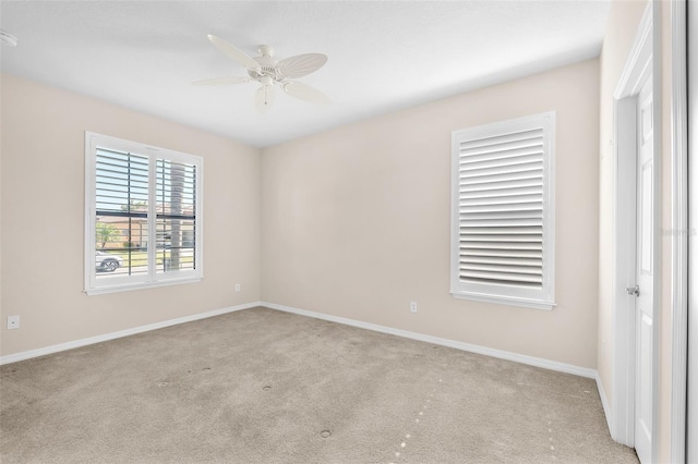 unfurnished room featuring light carpet, a ceiling fan, and baseboards