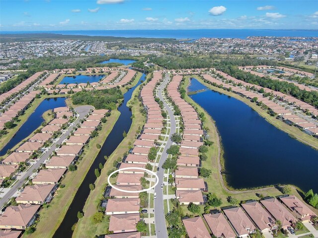 aerial view of property's location featuring a nearby body of water and nearby suburban area
