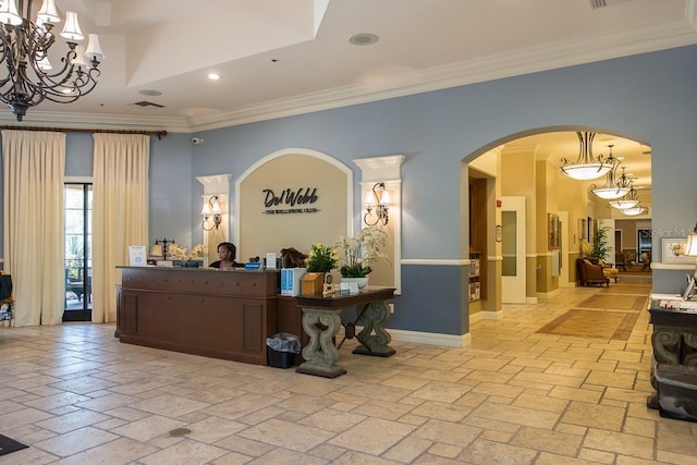 welcome area with ornamental molding, recessed lighting, arched walkways, and a chandelier