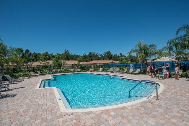 community pool featuring fence and a patio area