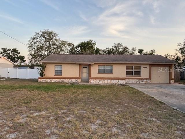 12230 Skyler Ln, Spring Hill, FL 34609 - ranch-style house featuring an attached garage, stucco siding, driveway, and stone siding