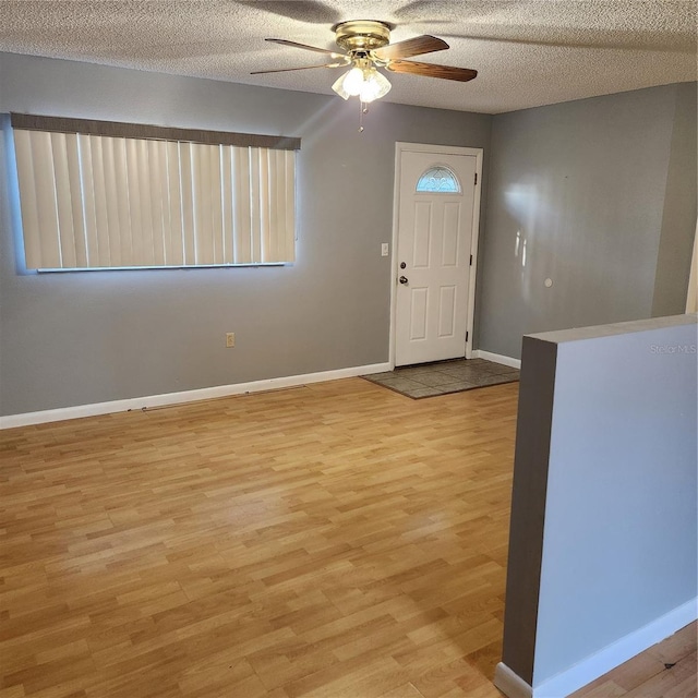 12230 Skyler Ln, Spring Hill, FL 34609 - entryway featuring light wood-style floors, baseboards, a ceiling fan, and a textured ceiling