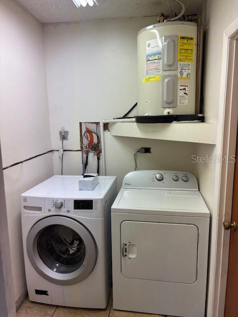 12230 Skyler Ln, Spring Hill, FL 34609 - washroom with washing machine and clothes dryer and electric water heater