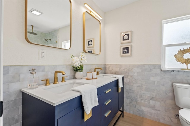 5724 Dr Martin Luther King Jr St N Unit J, Saint Petersburg, FL 33703 - full bath featuring tile walls, toilet, a shower, double vanity, and a wainscoted wall