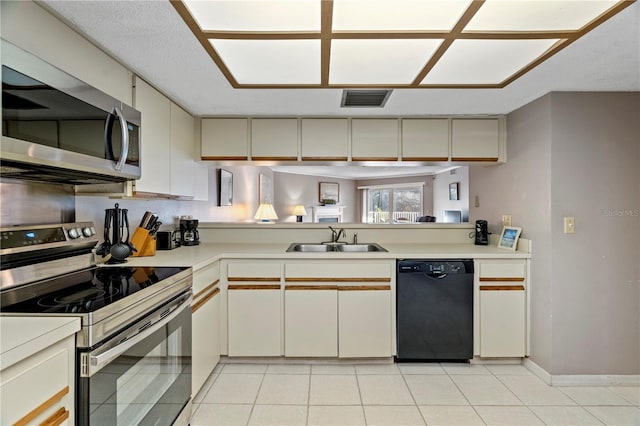 18400 Gulf Blvd Unit 1105, Indian Shores, FL 33785 - kitchen with appliances with stainless steel finishes, a sink, light countertops, and light tile patterned flooring