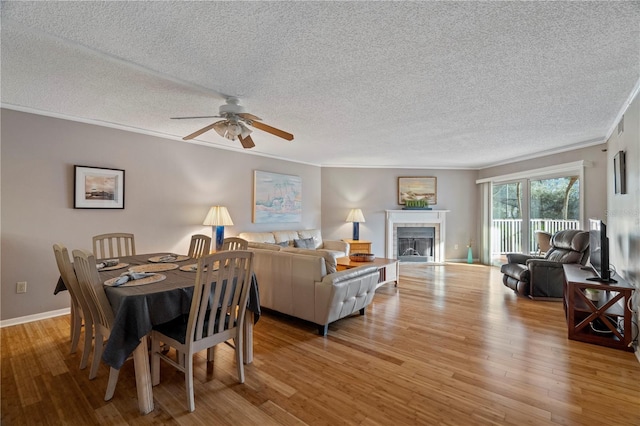 18400 Gulf Blvd Unit 1105, Indian Shores, FL 33785 - dining space with ornamental molding, wood finished floors, a textured ceiling, a ceiling fan, and a fireplace