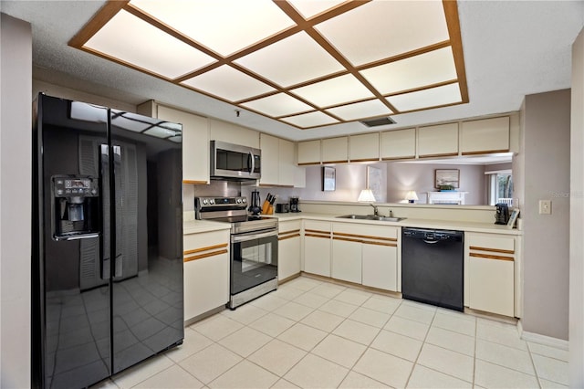 18400 Gulf Blvd Unit 1105, Indian Shores, FL 33785 - kitchen with black appliances, a sink, light countertops, and cream cabinetry