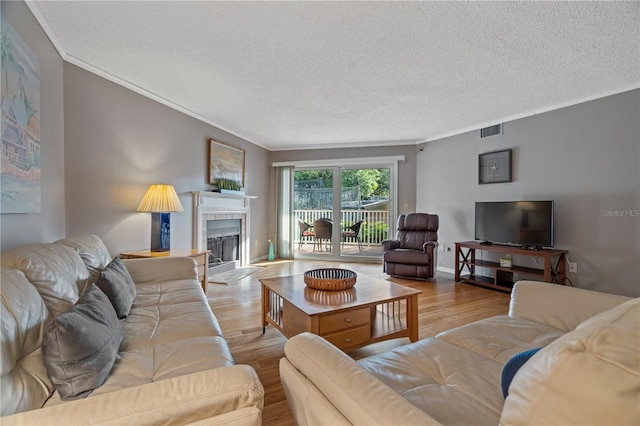 18400 Gulf Blvd Unit 1105, Indian Shores, FL 33785 - living area featuring wood finished floors, ornamental molding, a fireplace, a textured ceiling, and baseboards