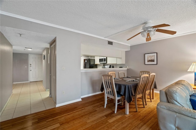 18400 Gulf Blvd Unit 1105, Indian Shores, FL 33785 - dining area with a textured ceiling, a ceiling fan, wood finished floors, baseboards, and ornamental molding