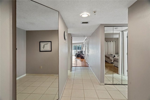 18400 Gulf Blvd Unit 1105, Indian Shores, FL 33785 - hall featuring light tile patterned floors, baseboards, and a textured ceiling