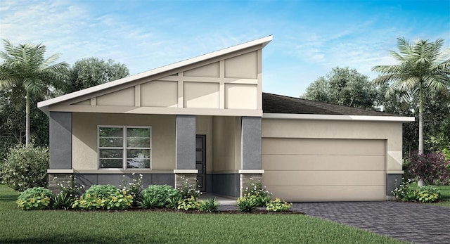 view of front of home with a garage, driveway, stucco siding, and a front yard