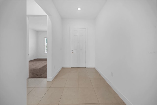 hallway featuring baseboards and light tile patterned flooring