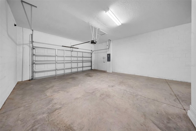 garage with a garage door opener, electric panel, and concrete block wall