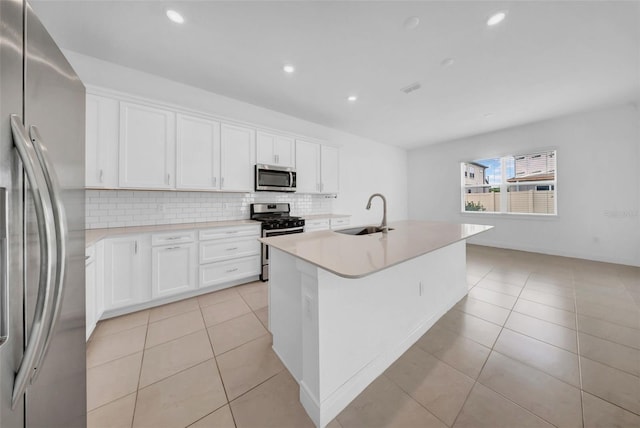 kitchen with stainless steel appliances, a sink, light tile patterned flooring, decorative backsplash, and recessed lighting