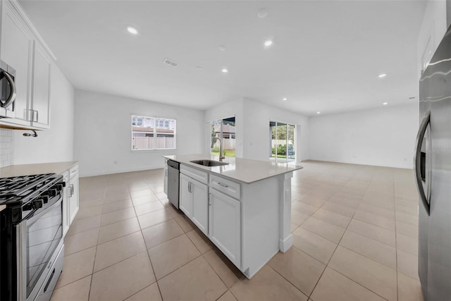 kitchen featuring stainless steel appliances, a sink, white cabinetry, light countertops, and recessed lighting