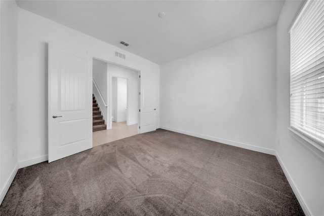 empty room featuring carpet flooring and baseboards