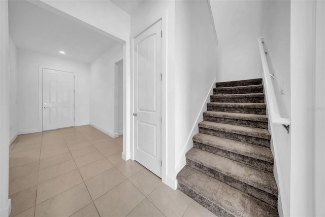 stairs with tile patterned floors and baseboards